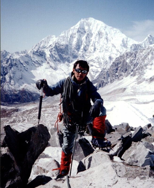 Nima Gyalzen Sherpa on summit of Yala Peak with Langtang Lirung in background