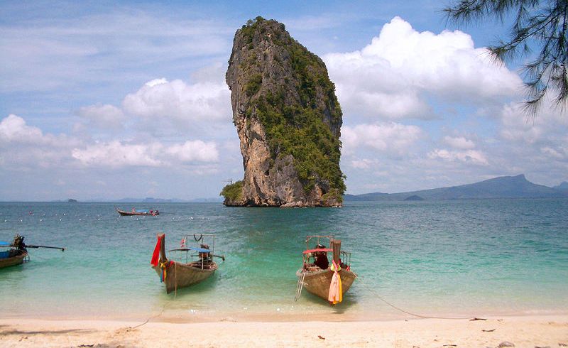 Boats and limestone sea stack at Hat Ton Sai at Phra Nang near Krabi in Southern Thailand